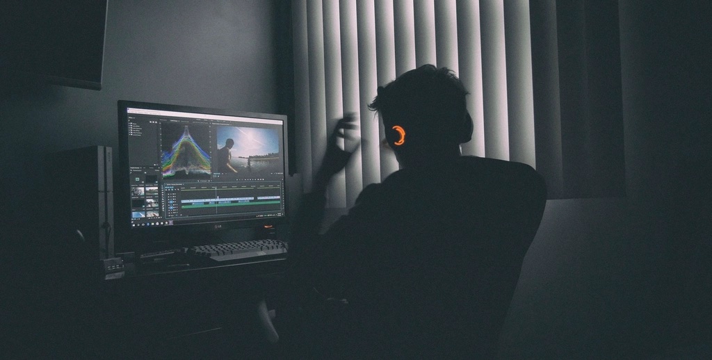 Editor working on a video timeline in a dark edit suite